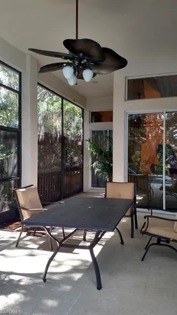 a living room with patio furniture and a floor to ceiling window