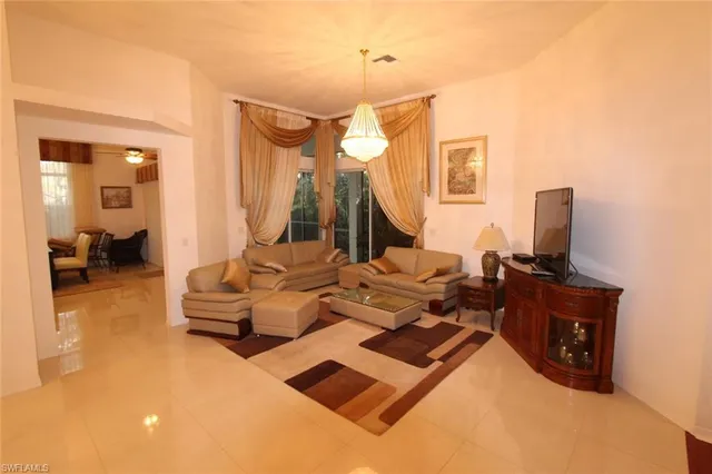 a living room with furniture a lamp and a flat screen tv