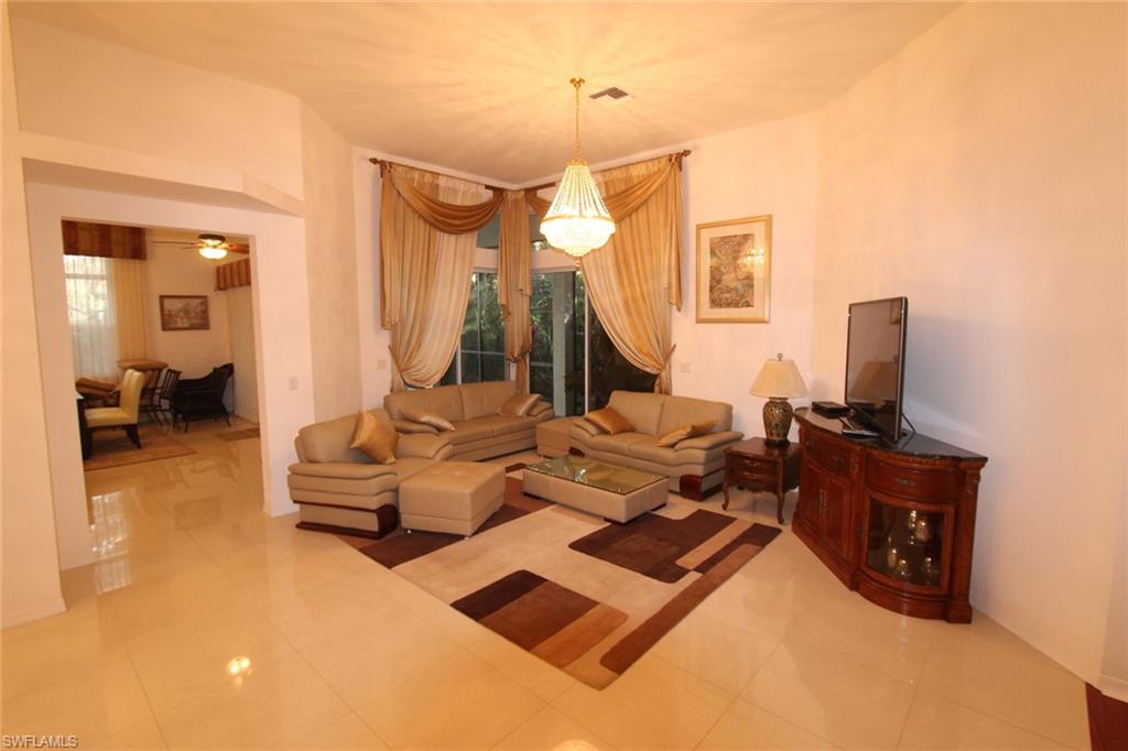 8526 Peppertree Way Naples, FL 34114 - Photo 4 of 14 a living room with furniture a lamp and a flat screen tv