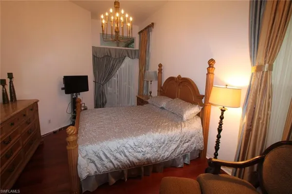 a bedroom with bed and wooden floor