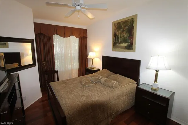 a bedroom with a bed and a flat tv screen on a dresser