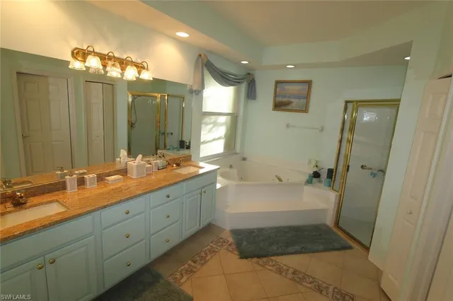 a spacious bathroom with a double vanity sink a large mirror and shower