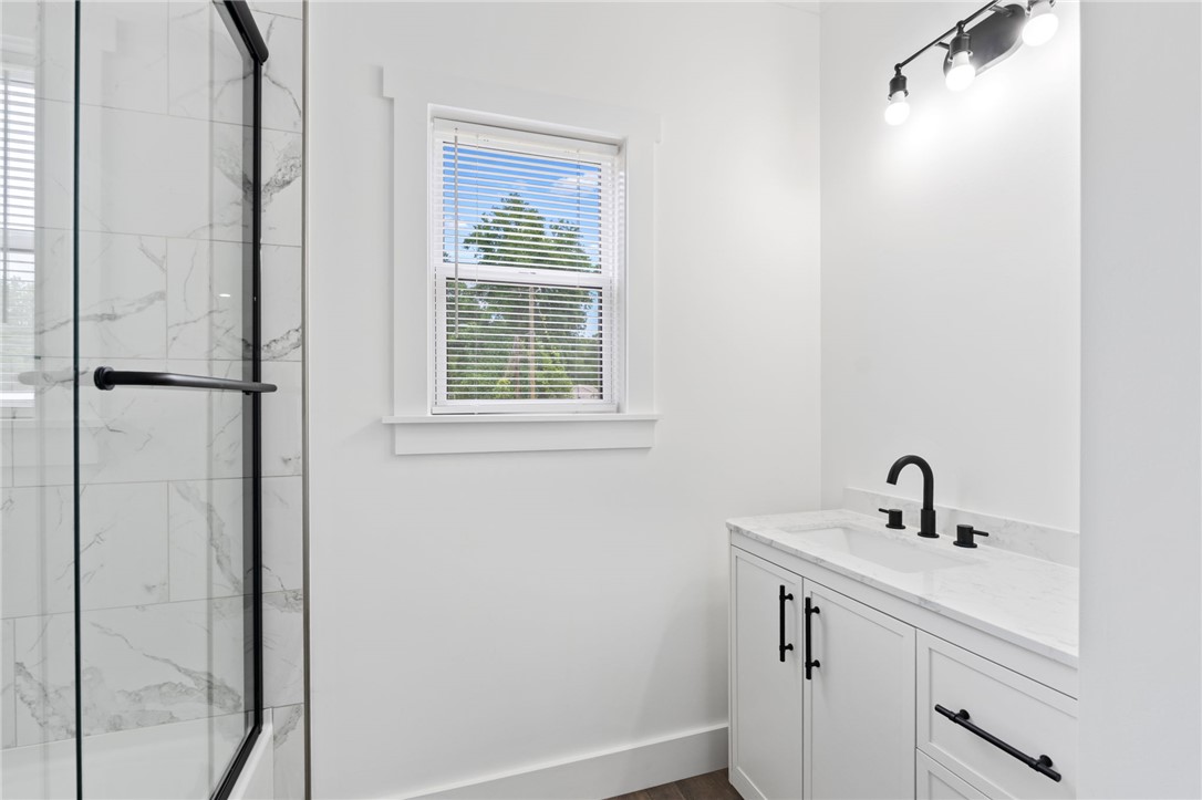 914 Smith Grove Road Easley, SC 29640 - Photo 25 of 37 A well-lit bathroom with a modern vanity and a spacious, glass-enclosed shower.