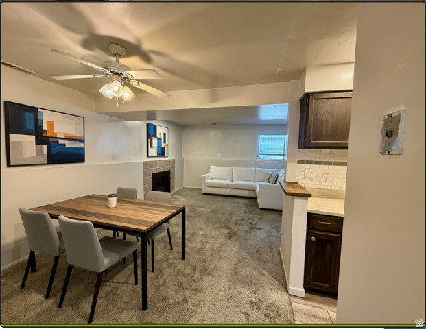 169 East 100 North, Unit B Logan, UT 84321 - Photo 3 of 11 Open-concept living space featuring a fireplace with stone surround, dining room conveniently located adjacent to kitchen and living room