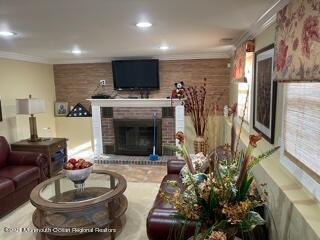 51 Homestead Road Freehold, NJ 07728 - Photo 16 of 20 a living room with furniture a fireplace and a flat screen tv