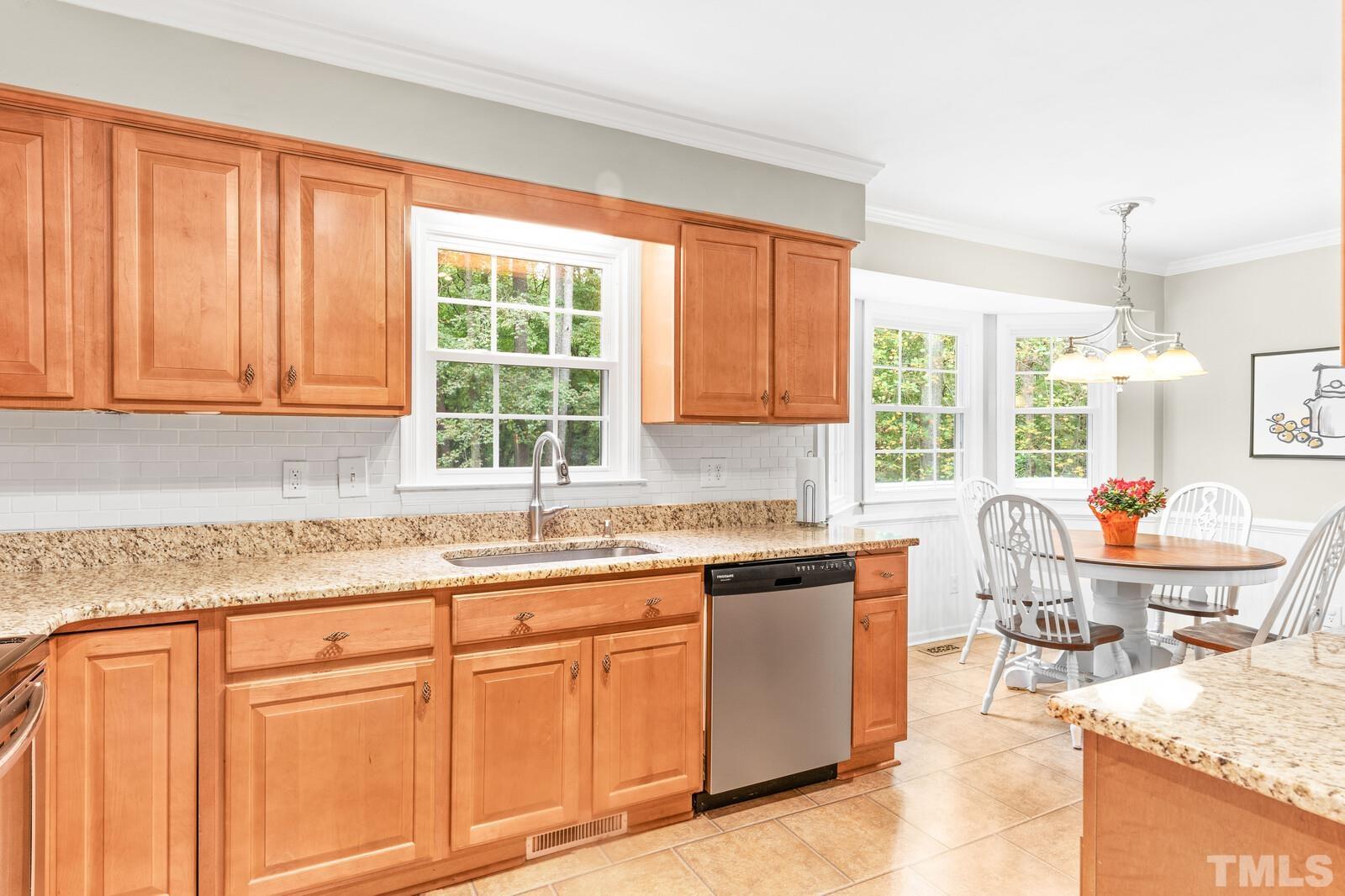 8312 Heel Stone Court Raleigh, NC 27613 - Photo 11 of 30 a kitchen with granite countertop sink window and cabinets