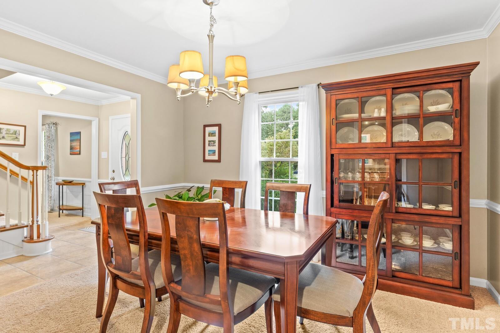 8312 Heel Stone Court Raleigh, NC 27613 - Photo 15 of 30 a view of a dining room with furniture large windows and wooden floor