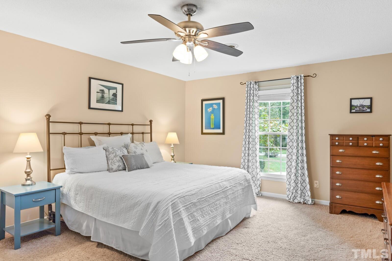 8312 Heel Stone Court Raleigh, NC 27613 - Photo 16 of 30 a bedroom with a bed a dresser and a window