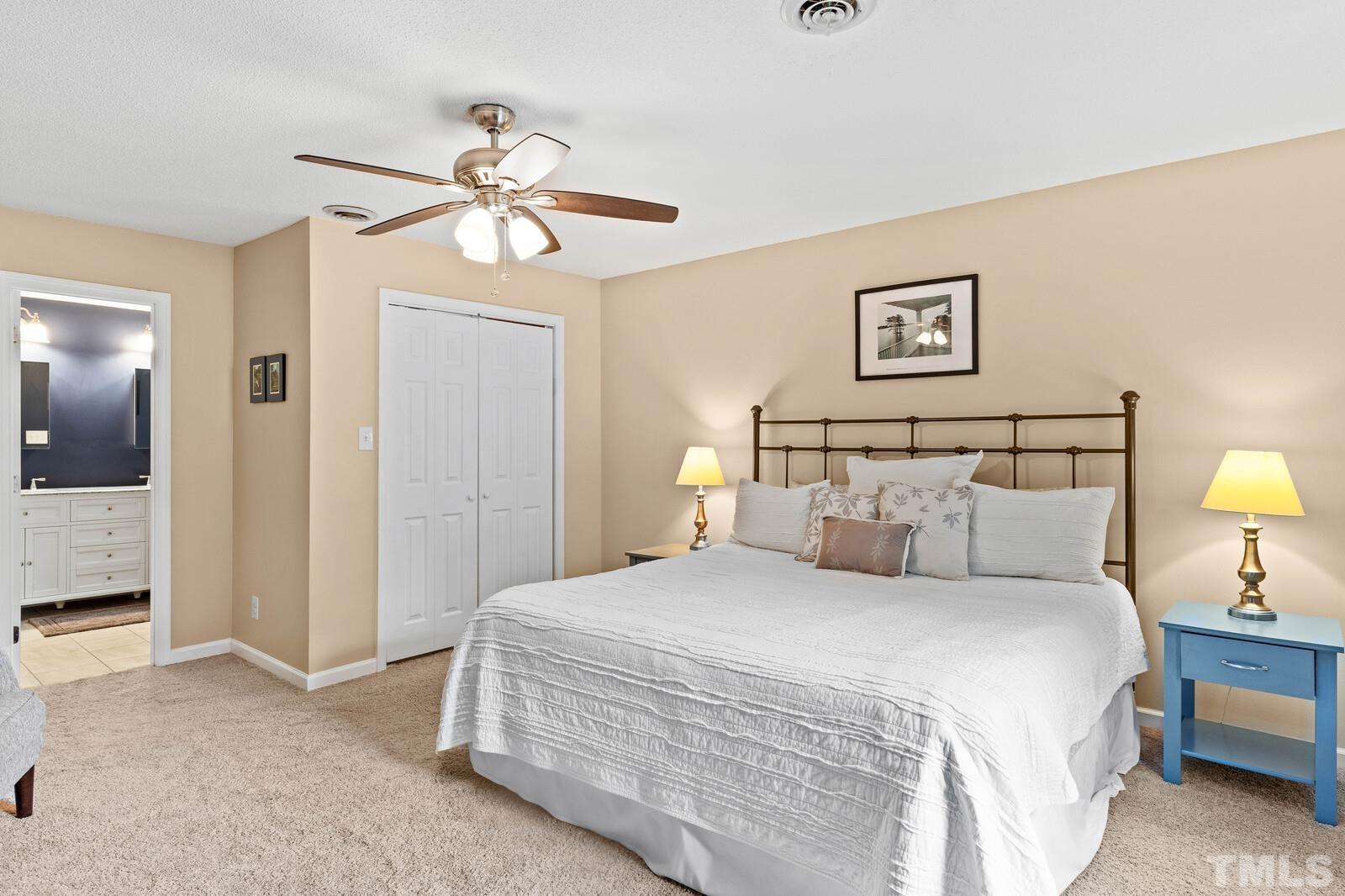 8312 Heel Stone Court Raleigh, NC 27613 - Photo 17 of 30 a bedroom with a bed and a chandelier