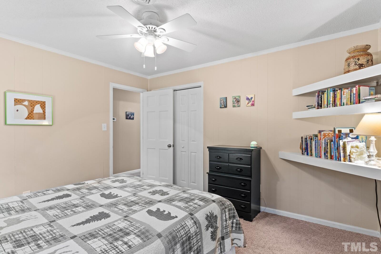 8312 Heel Stone Court Raleigh, NC 27613 - Photo 20 of 30 a bedroom with a bed and a book shelf