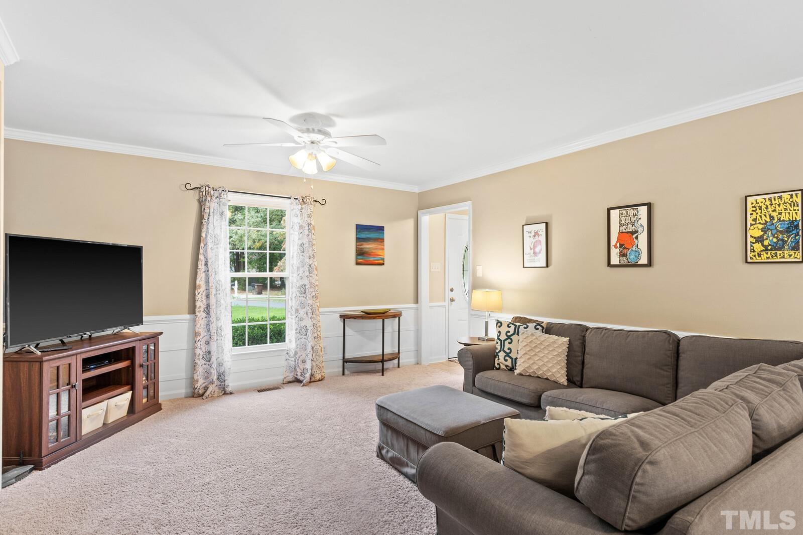 8312 Heel Stone Court Raleigh, NC 27613 - Photo 4 of 30 a living room with furniture a flat screen tv and a fireplace