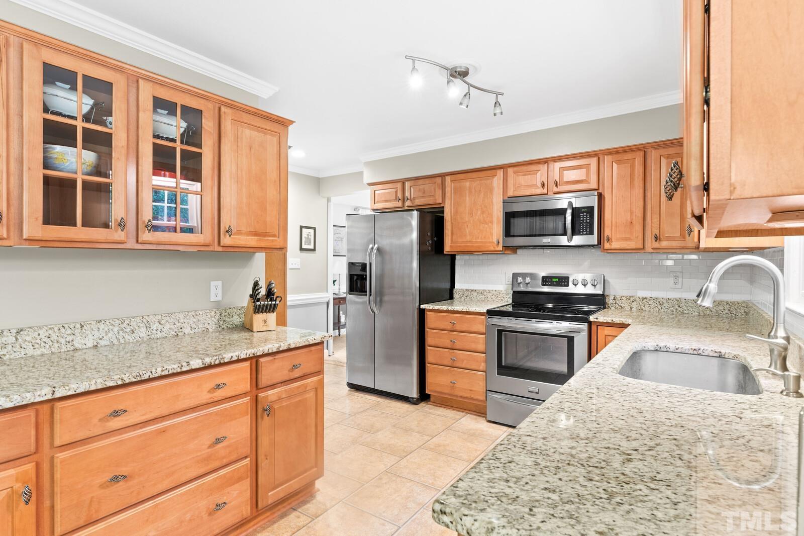 8312 Heel Stone Court Raleigh, NC 27613 - Photo 10 of 30 a kitchen with stainless steel appliances granite countertop a stove sink microwave and refrigerator