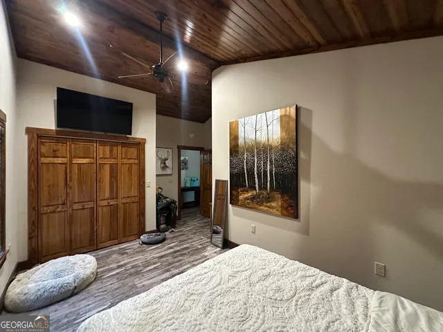 a large bedroom with a large bed and a flat screen tv