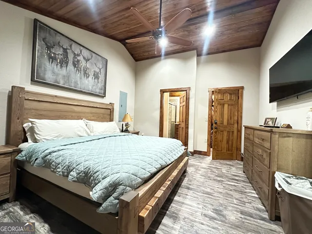 a bedroom with a bed wooden floor and a window