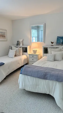 a bedroom with two beds and painting on the wall