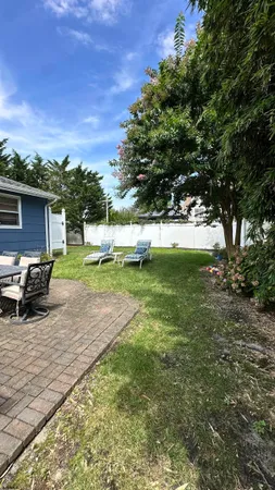 a view of a backyard with a garden and entertaining space