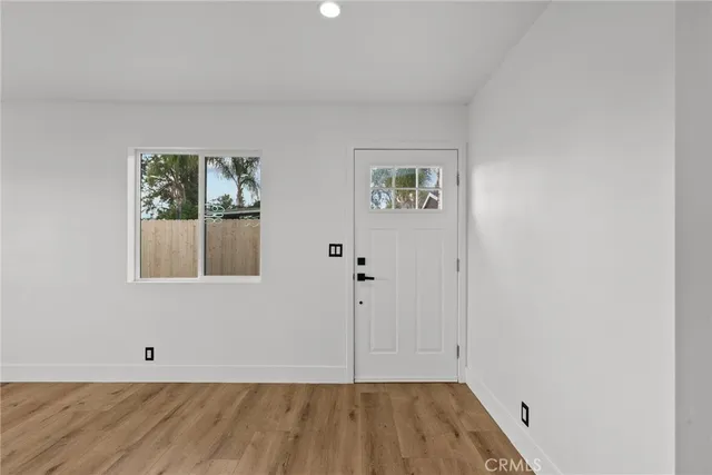 a view of a room with wooden floor and window