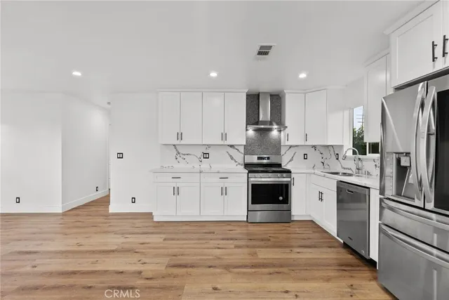 a kitchen with granite countertop white cabinets and stainless steel appliances
