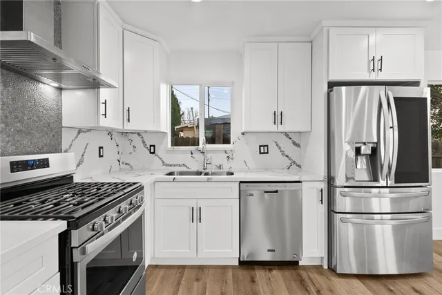 a kitchen with white cabinets sink and stainless steel appliances