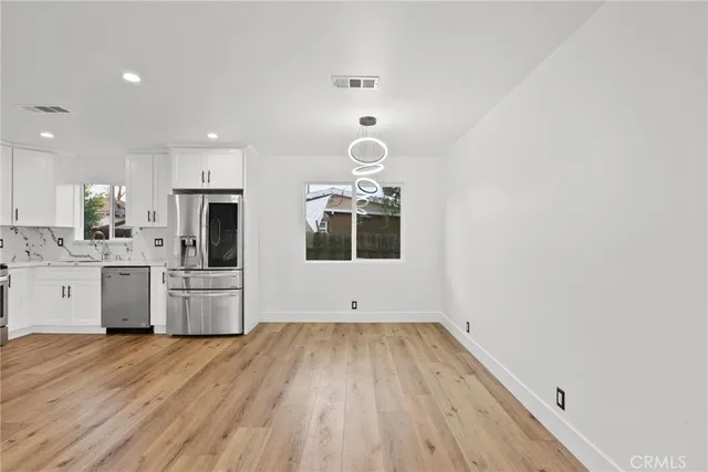 a kitchen with wooden floors and white appliances