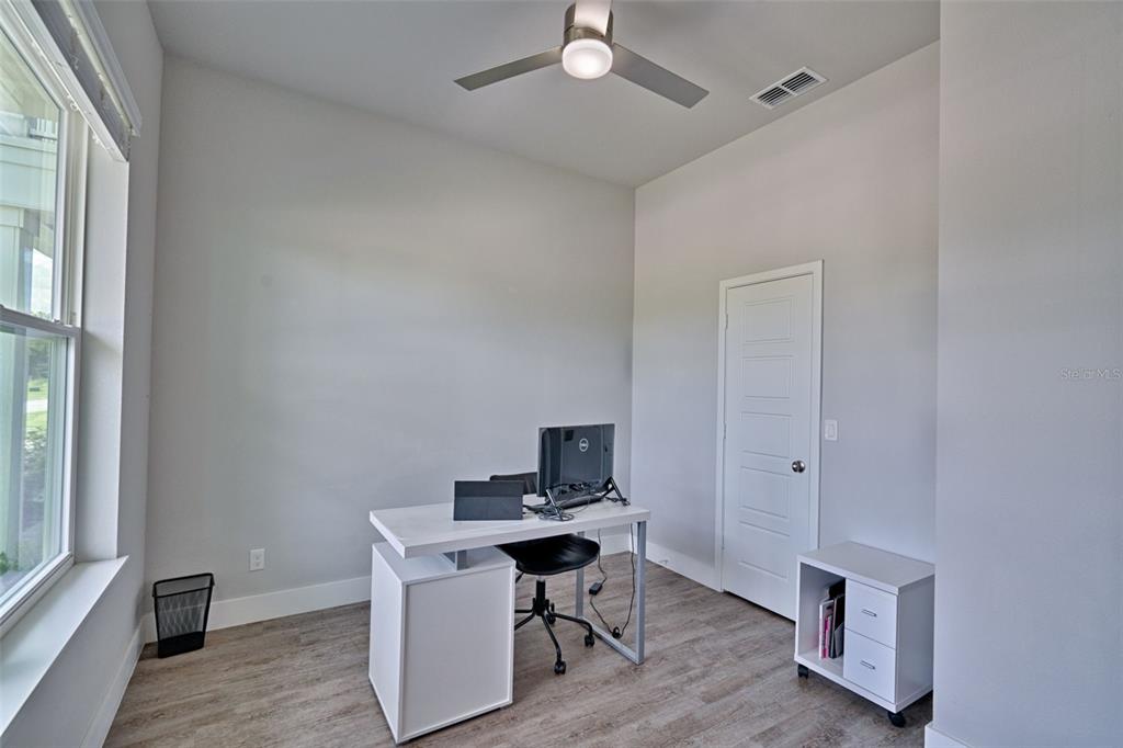 6464 Southwest 77th Street Gainesville, FL 32608 - Photo 18 of 41 a workspace with furniture and wooden floor