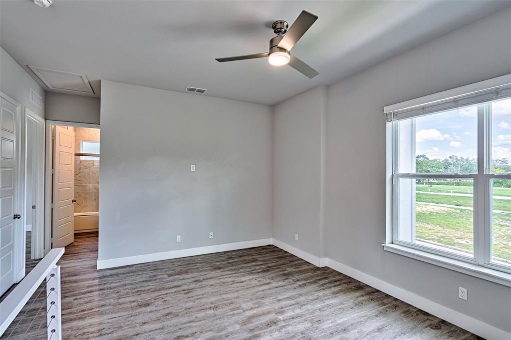 6464 Southwest 77th Street Gainesville, FL 32608 - Photo 25 of 41 a view of empty room with wooden floor and fan