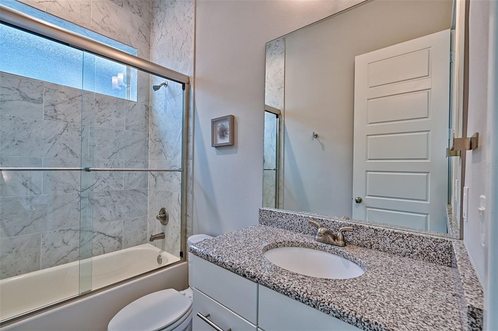6464 Southwest 77th Street Gainesville, FL 32608 - Photo 33 of 41 a bathroom with a granite countertop sink toilet and shower