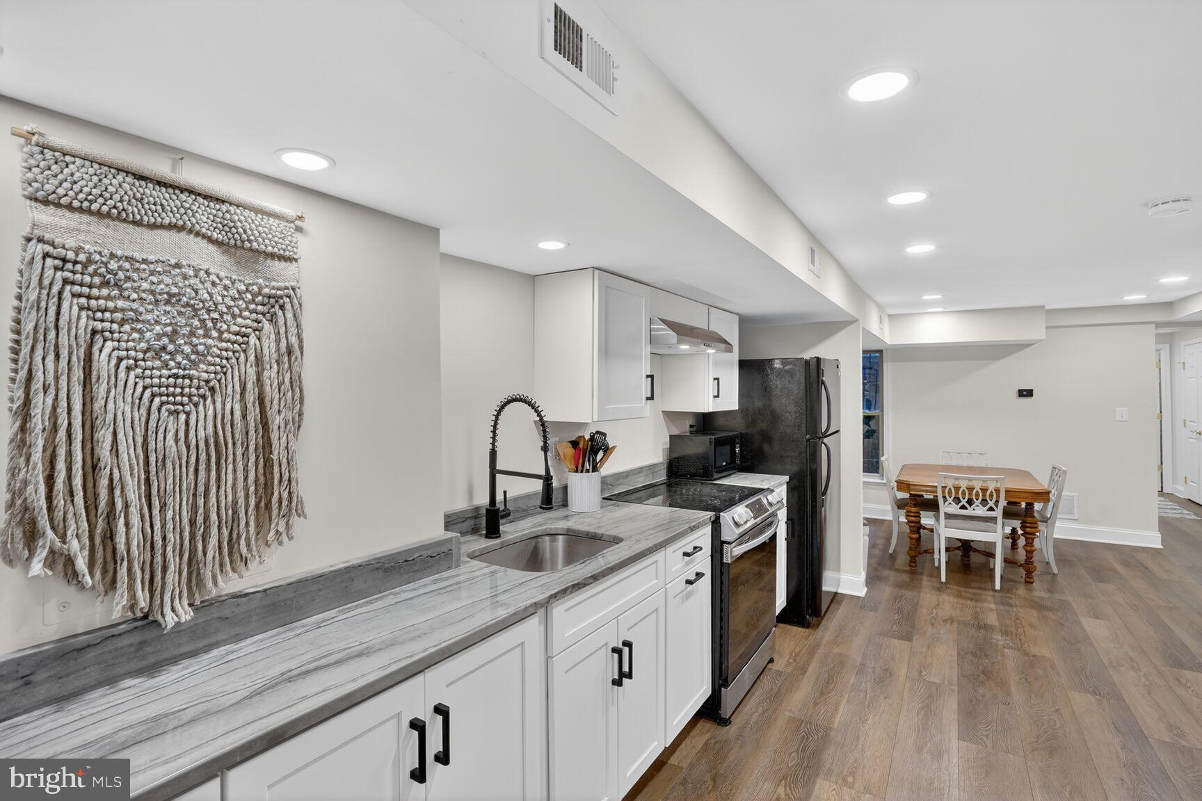 1316 Florida Avenue Northwest Washington, DC 20009 - Photo 29 of 43 a kitchen with stainless steel appliances granite countertop a sink cabinets and wooden floor