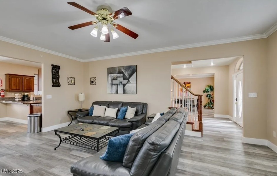 6520 Turtle Hill Road Las Vegas, NV 89110 - Photo 13 of 59 Living room with light wood-style flooring, ornamental molding, stairway, and ceiling fan