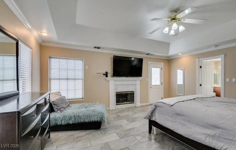 6520 Turtle Hill Road Las Vegas, NV 89110 - Photo 32 of 59 Bedroom featuring a raised ceiling, a fireplace, a ceiling fan, and ornamental molding