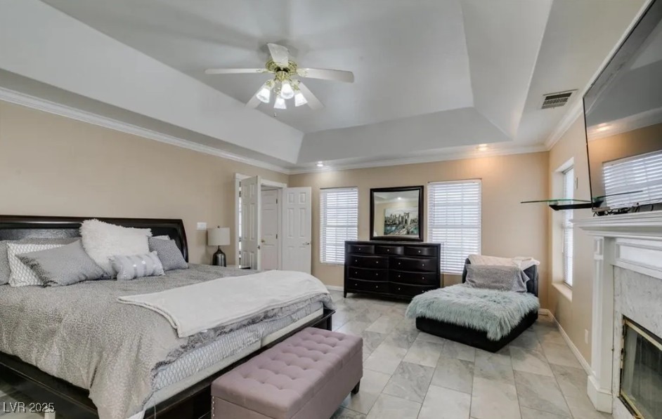 6520 Turtle Hill Road Las Vegas, NV 89110 - Photo 33 of 59 Bedroom featuring a raised ceiling, ornamental molding, a premium fireplace, and a ceiling fan
