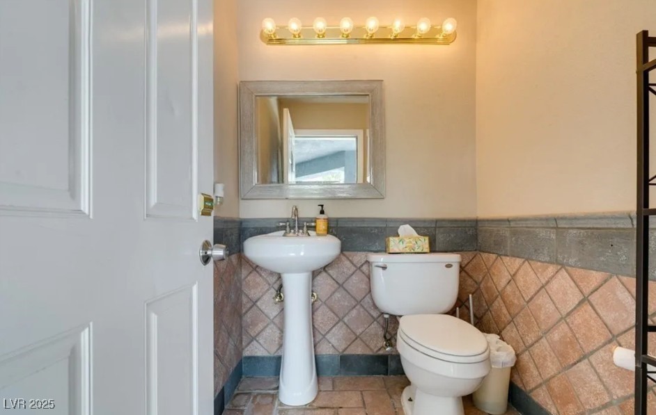 6520 Turtle Hill Road Las Vegas, NV 89110 - Photo 48 of 59 Half bathroom with tile walls and wainscoting