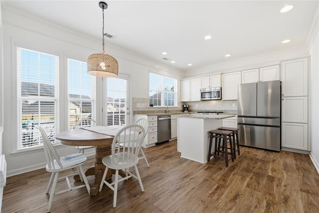 503 White Oak Path Canton, GA 30115 - Photo 17 of 47 a view of a dining room and livingroom with furniture wooden floor a chandelier