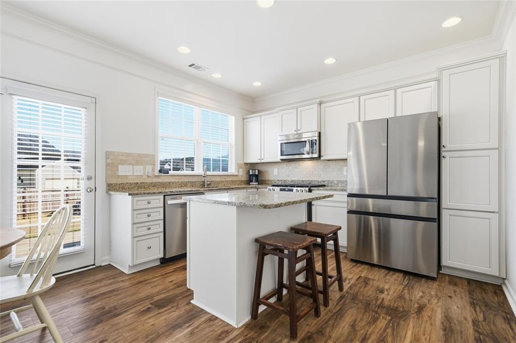 503 White Oak Path Canton, GA 30115 - Photo 18 of 47 a kitchen with a refrigerator a white stove top oven cabinets and a dining table