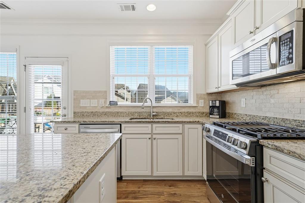 503 White Oak Path Canton, GA 30115 - Photo 19 of 47 a kitchen with stainless steel appliances granite countertop a sink stove and cabinets