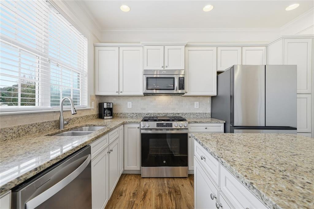 503 White Oak Path Canton, GA 30115 - Photo 20 of 47 a kitchen with granite countertop a sink stove and refrigerator