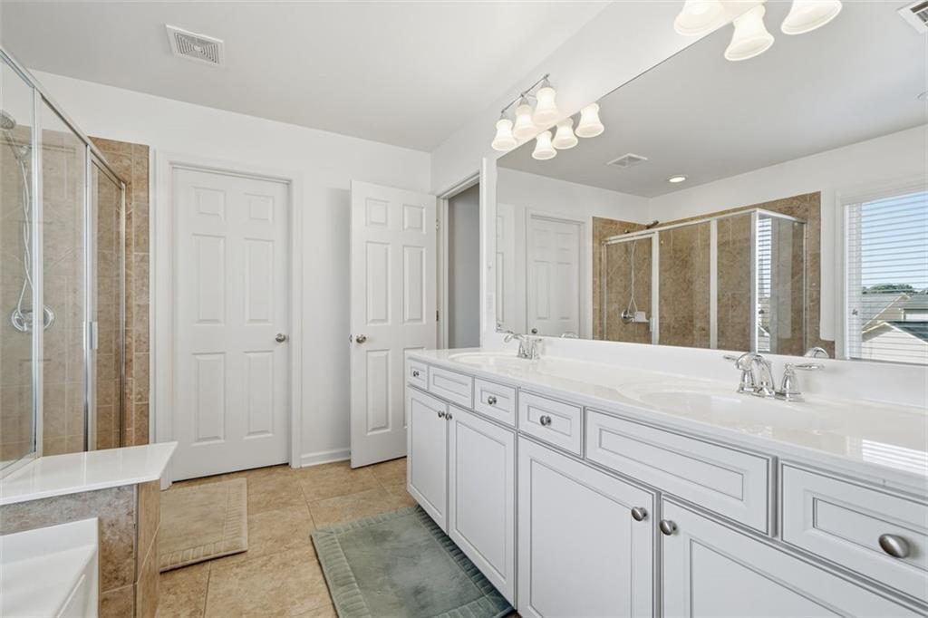 503 White Oak Path Canton, GA 30115 - Photo 35 of 47 a spacious bathroom with a granite countertop sink a mirror and a shower
