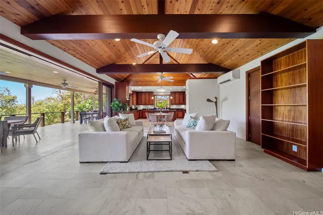 a living room with furniture a ceiling fan and a large window