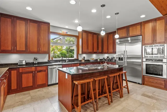 a kitchen with stainless steel appliances granite countertop a stove a sink dishwasher and a refrigerator