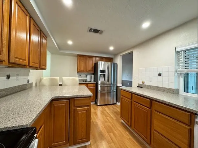 a large kitchen with stainless steel appliances lots of counter space and a sink