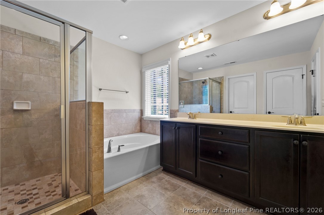 141 Pine Hawk Drive Spring Lake, NC 28390 - Photo 16 of 21 a bathroom with a tub a sink shower and mirror