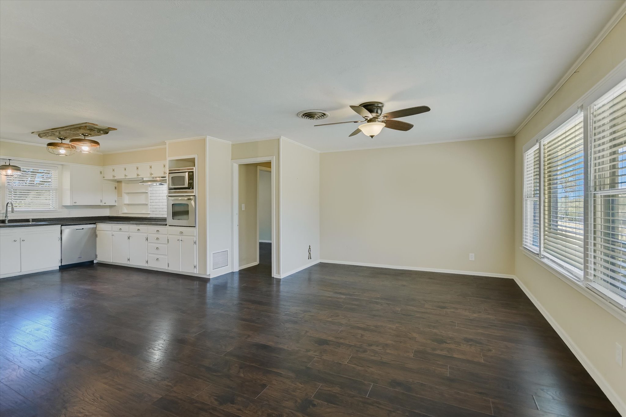 5421 Purgatory Road San Marcos, TX 78666 - Photo 7 of 38 an empty room with wooden floor a ceiling fan and windows
