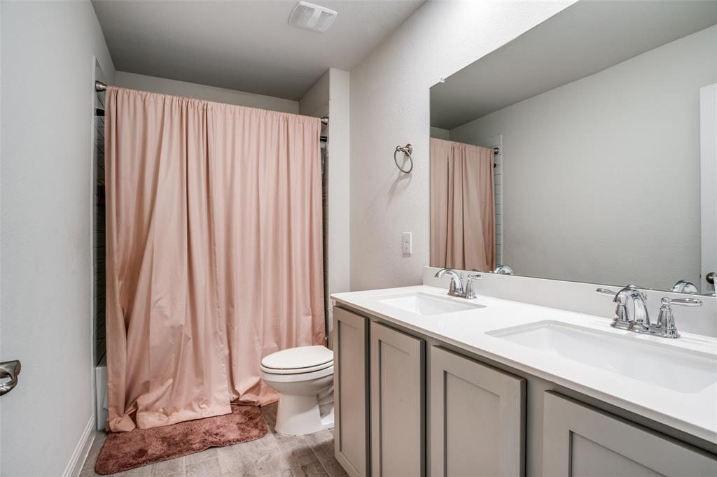 10421 Table Blf Street Aubrey, TX 76227 - Photo 19 of 25 a bathroom with a sink a toilet and a mirror