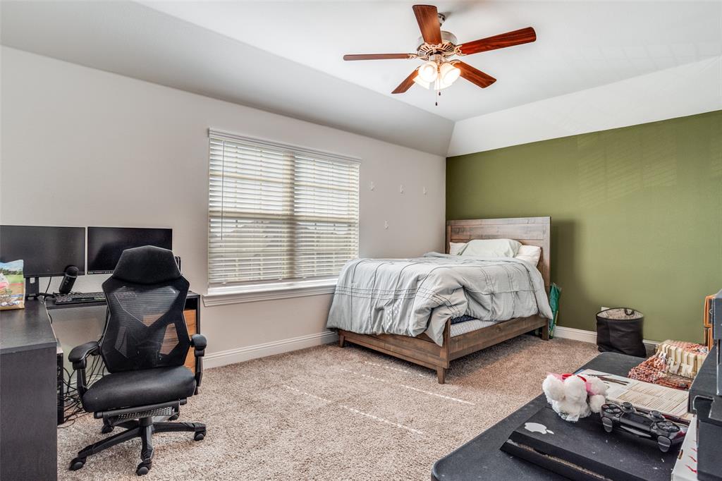 10421 Table Blf Street Aubrey, TX 76227 - Photo 20 of 25 a bedroom with a bed and a chandelier