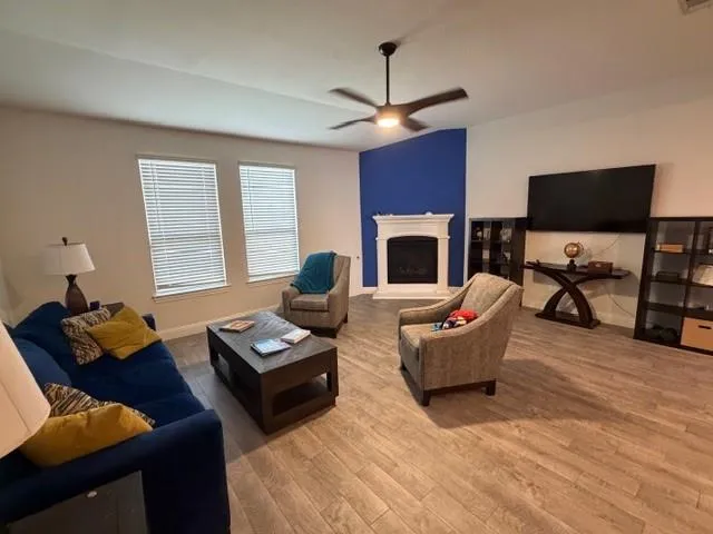 a living room with furniture a fireplace and a flat screen tv