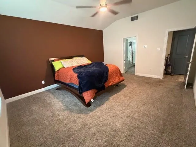 a bed sitting in a room next to a lamp