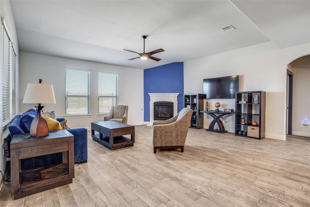10421 Table Blf Street Aubrey, TX 76227 - Photo 7 of 25 a living room with furniture a fireplace and a flat screen tv