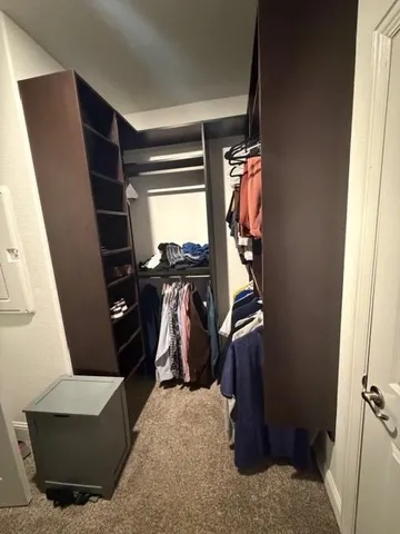 a view of walk in closet with clothes and shoes