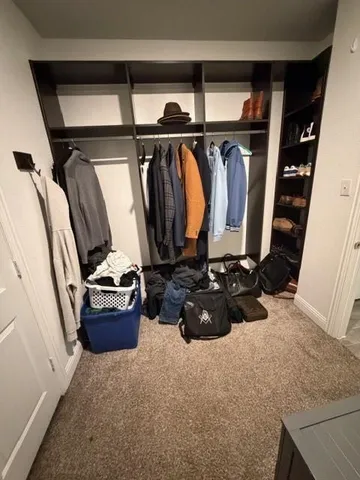 a room with walk in closet and wooden floor
