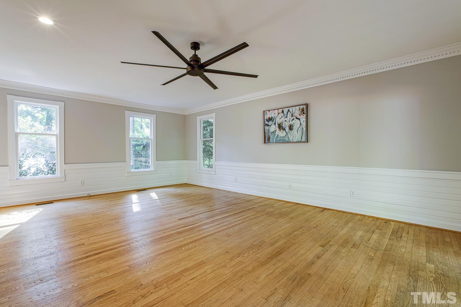 11709 Old Creedmoor Road Raleigh, NC 27613 - Photo 5 of 16 a view of empty room with wooden floor and fan